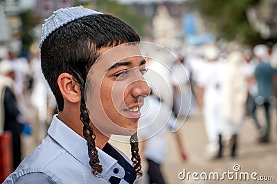 Young hasid in a traditional kippah on the street in a crowd of pilgrims. Rosh Hashanah, Jewish New Year. Editorial Stock Photo