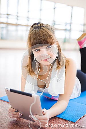 Young healthy woman uses a tablet computer in fitness. Stock Photo