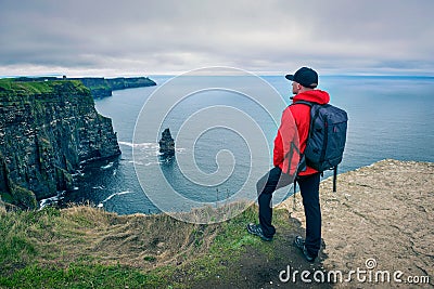 Young hiker standing at the cliffs of Moher Stock Photo