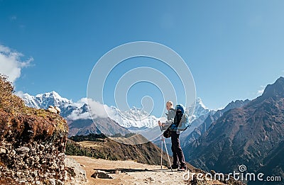 Young hiker backpacker man with trekking poles enjoying the Ama Dablam 6814m peak mountain during high altitude acclimatization Stock Photo