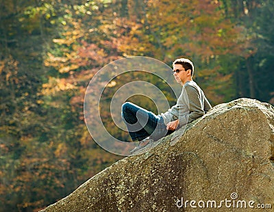 Young hiker relaxing on rock Stock Photo