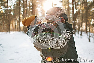 Young hipster couple hugging each other in winter forest Stock Photo