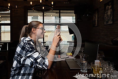 Young hipster freelancer business woman or college student sitting in cafeteria waiting for lunch. Expat businessperson on lunch b Stock Photo