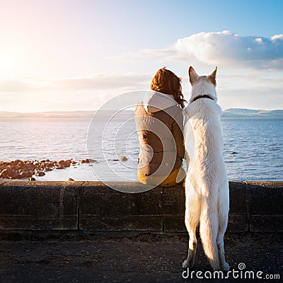 Young hipster girl with her pet dog at a seaside Stock Photo