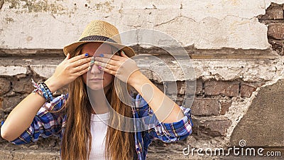 Young hipster girl standing in the street old town and closes his eyes his hands with colored nails. Stock Photo