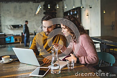 Young hipster male and female working laptop together in cafe Stock Photo