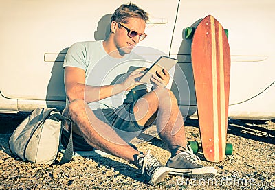 Young hipster man with tablet sitting next his car Stock Photo