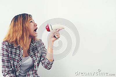 Young hipster woman shouting through megaphone. Stock Photo