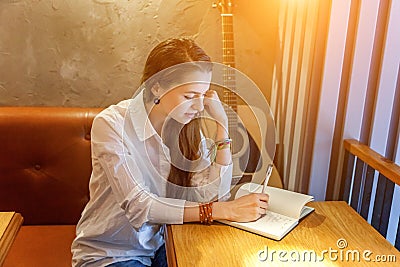 Young girl playing guitar in cafe Stock Photo