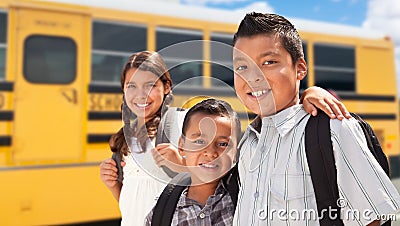 Young Hispanic Boys and Girl Walking Near School Bus Stock Photo