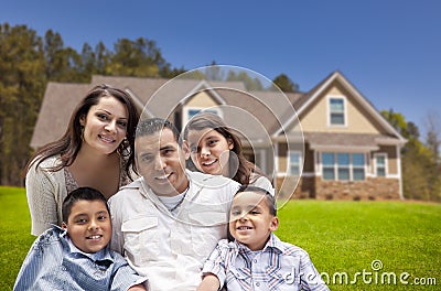 Young Hispanic Family in Front of Their New Home Stock Photo