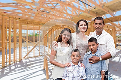 Young Hispanic Family On Site Inside New Home Construction Framing. Stock Photo