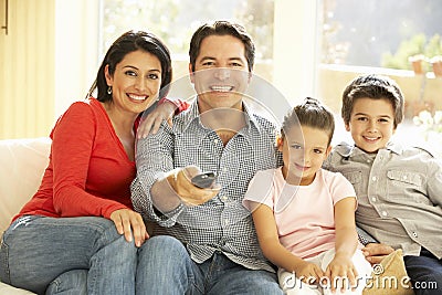 Young Hispanic Family Watching TV At Home Stock Photo