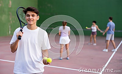 Young hispanic frontenis player on open-air fronton court with racket and balls Stock Photo