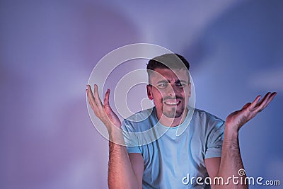 Young Hispanic male with hands up with gesture of doubt or question on white background Stock Photo