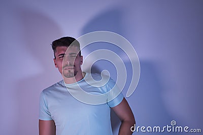 Young Hispanic male with one eye open and one eye closed with a distrustful gesture on white background Stock Photo