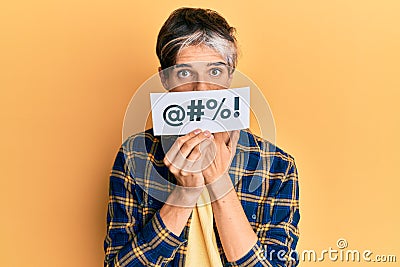 Young hispanic man covering mouth with insult message paper covering mouth with hand, shocked and afraid for mistake Stock Photo