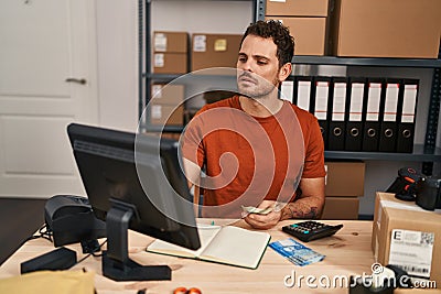 Young hispanic man ecommerce business worker counting chile pesos banknotes at office Stock Photo