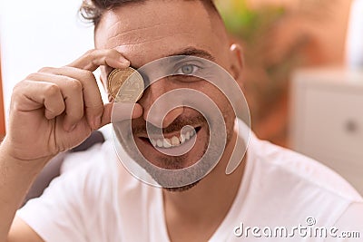 Young hispanic man holding litecoin crypto currency over eye at home Stock Photo