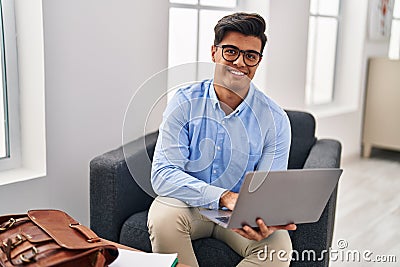 Young hispanic man psychologist using laptop at psychology clinic Stock Photo