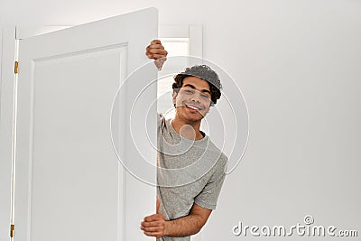 Young hispanic man smiling happy opening door of new home Stock Photo