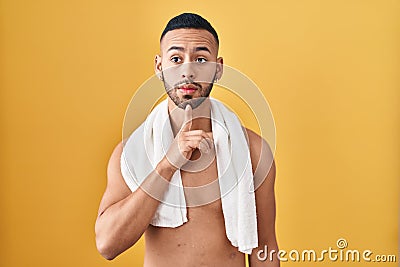 Young hispanic man standing shirtless with towel thinking concentrated about doubt with finger on chin and looking up wondering Stock Photo