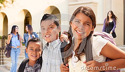 Young Hispanic Student Children Wearing Backpacks On School Campus Stock Photo