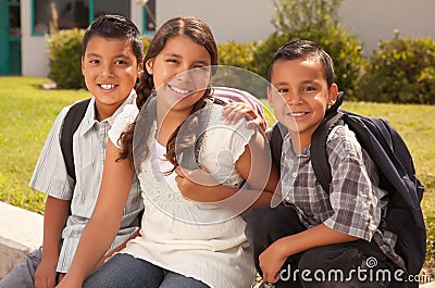 Young Hispanic Student Children Wearing Backpacks On School Campus Stock Photo