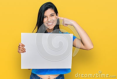 Young hispanic woman holding blank empty banner pointing finger to one self smiling happy and proud Stock Photo