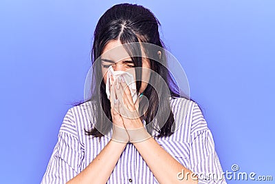 Young hispanic woman illness using paper handkerchief on nose Stock Photo