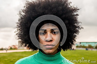 Young Hispanic woman looking in front of a camera in park Stock Photo