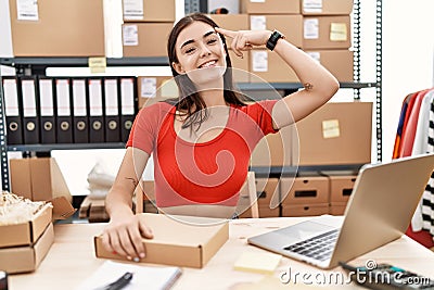 Young hispanic woman preparing order working at storehouse smiling pointing to head with one finger, great idea or thought, good Stock Photo