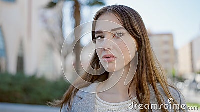 Young hispanic woman standing with serious expression looking at the camera at park Stock Photo