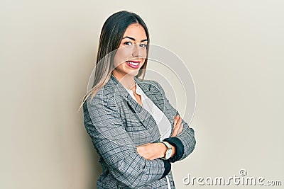 Young hispanic woman wearing business clothes with arms crossed gesture smiling with a happy and cool smile on face Stock Photo
