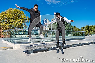 Young Hispanics having fun and jumping from a bench in a public park Stock Photo
