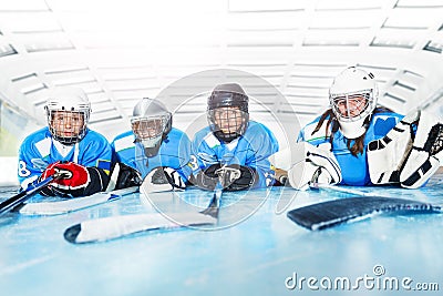 Young hockey players laying on ice rink in line Stock Photo
