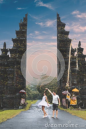 Young honeymoon couple on a big balinese gates background. Bali island, Indonesia. Stock Photo