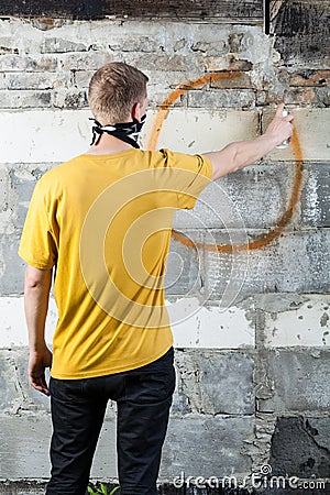 Young hooligan drawing a graffiti Stock Photo
