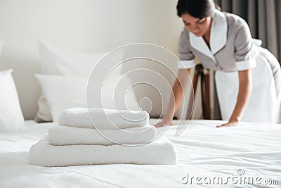 Young hotel maid setting up pillow on bed Stock Photo