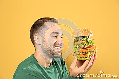 Young hungry man eating huge burger Stock Photo