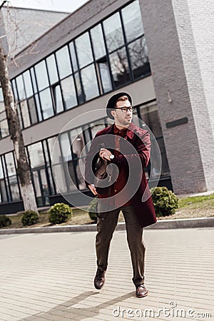 young hurry man in trendy clothes with bag running Stock Photo