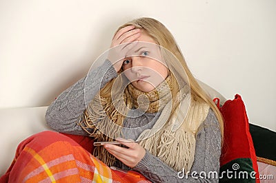 Young ill female checking her body temperatu Stock Photo