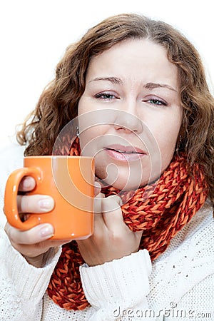 Young illness woman drinks tea with wrapping scarf on neck Stock Photo