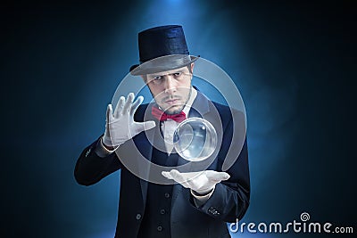 Young illusionist, magician or fortune teller is predicting future with crystal sphere Stock Photo