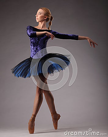 Young and incredibly beautiful ballerina in blue outfit is posing and dancing in studio. classical Stock Photo