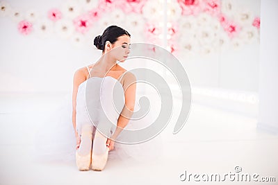 Young and incredibly beautiful ballerina is posing and dancing in a white studio full of light. Stock Photo