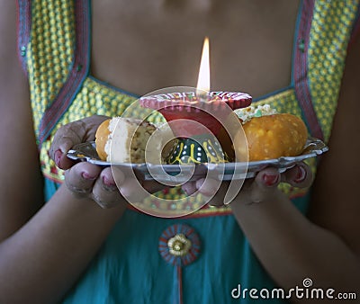 Young Indian Female dressed in traditional clothes Carrying Indian Diwali Sweets Stock Photo