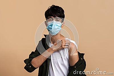 Young indian man in face mask showing he got vaccinated Stock Photo