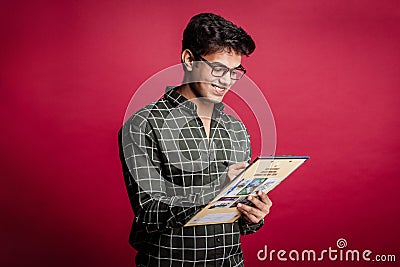 Young indian manager in glasses writing on a clip board Stock Photo