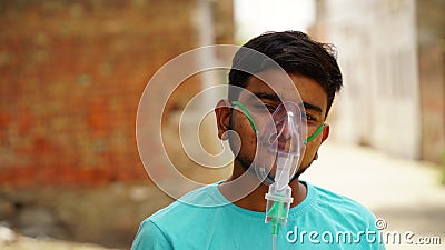 Young Indian taking Emergency Oxygen with Cannula outside of hospital Editorial Stock Photo